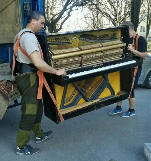 Грузчики вывозят пианино на утилизацию